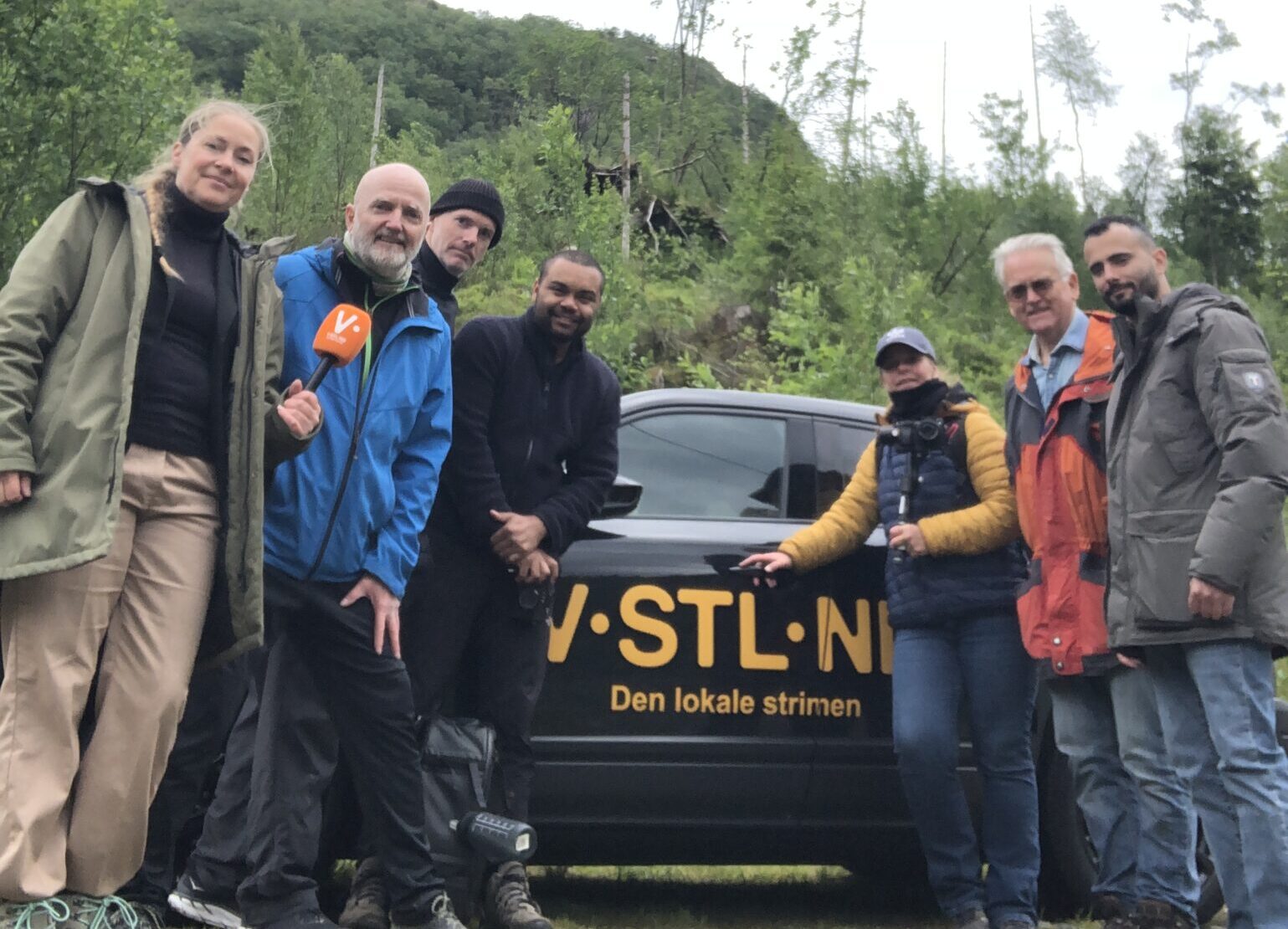 Hele filmteamet og gjengen i Isdalskvinnenprosjektet står foran vstlnd-tv-bilen, i skogholtet hvor Isdalskvinnen ble funnet.