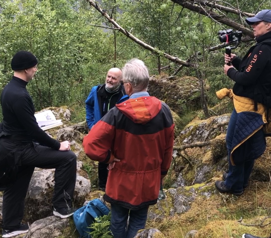 på åstedet, privatetterforsker Kenneth Berg holder en bok og snakker, mens krimforfatter Gunnar Staalesen og initiativtaker Arild Pedersen følger med. Helt til høyre står vstlnd.tv's Line Tofte Lone og filmer dem.