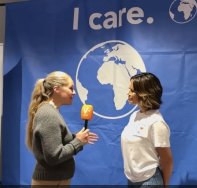 Reporter Elisabet Kolbrun Hansen i intervjusituasjon med initiativtaker bak miljaøplakaten, Louise Mohn, foran en plakat som sier: I care.