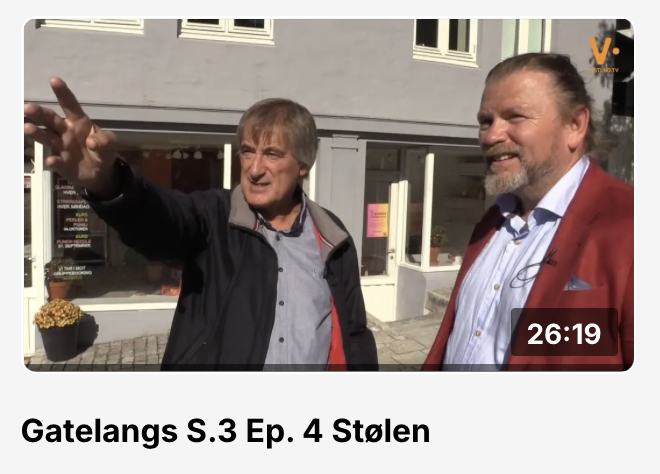 Lothepus står foran stavkirken sin med Vstlnd sin mikrofon i hånden, og har tatt over programlederjobben - for å presentere det nye gullforgylte kirkespiret 